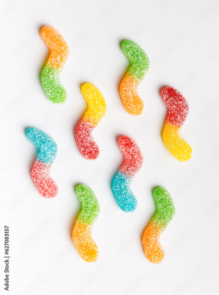 Multi-colored marmalade candies in sugar on a white background, top view. Multi-colored marmalade candies in sugar on a white background, top view.