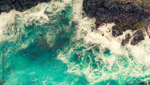 Turbulent waters near a rocky shoreline, amazing aerial view from drone