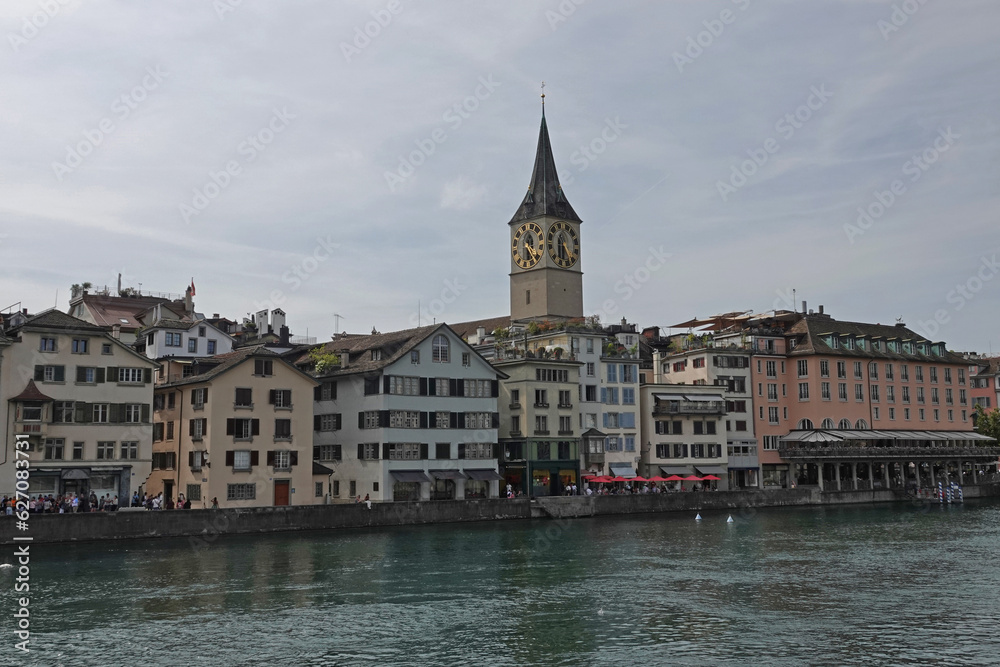 Old Town Zurich, Switzerland is shown during the day, with the Limmat River in the foreground.