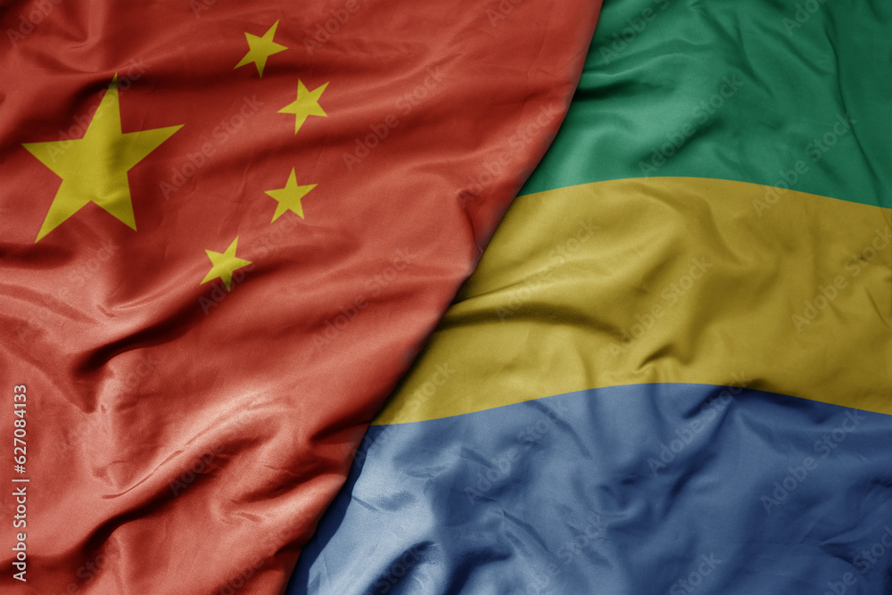 Fototapeta premium big waving national colorful flag of china and national flag of gabon .