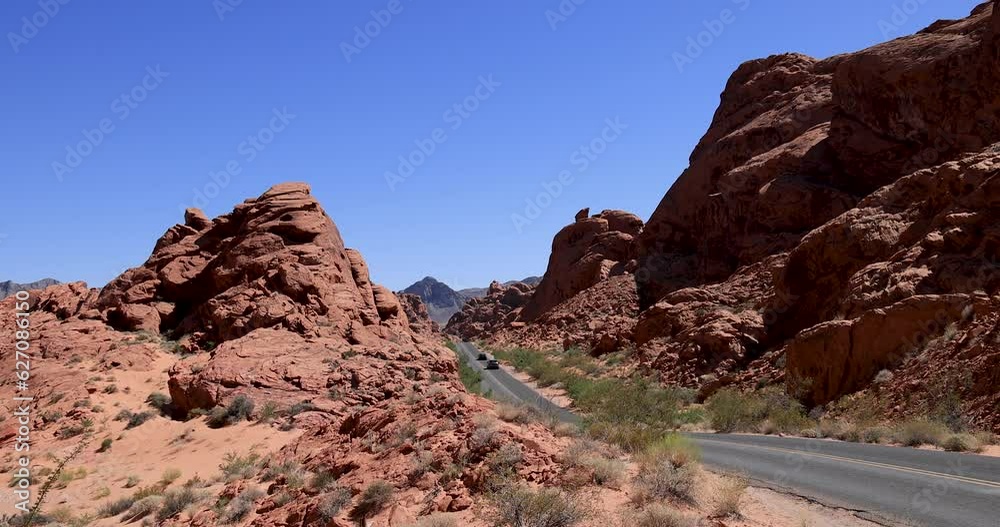 Red Rock Desert Nevada Valley of Fire road traffic cars. Recreation, travel, ecology and nature preservation. Mojave Desert. Dry arid landscape with wildlife, rock formations erosion. Red Rock Desert Nevada Valley of Fire road traffic cars. Recreation, travel, ecology and nature preservation. Mojave Desert. Dry arid landscape with wildlife, rock formations erosion.