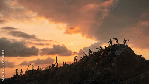 Miniature silhouettes of WWII American and German soldiers fighting under big sunset. War concept