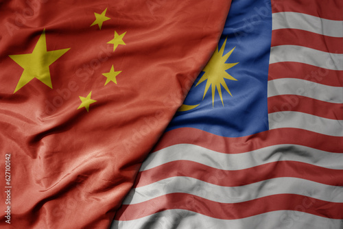 big waving national colorful flag of china and national flag of malaysia . photo