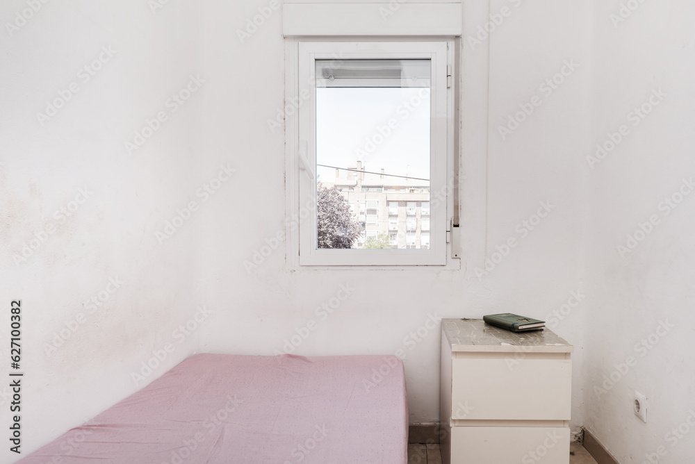 A spartan bedroom with dirty white walls A spartan bedroom with dirty white walls