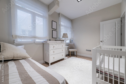 A simple bedroom with a single bed with a striped bedspread,