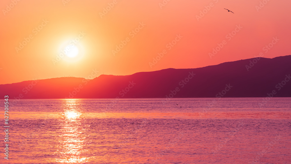 Obraz premium Sunset landscape. Sunset over sea and mountains. Colorful nature banner concept. Nature wallpaper