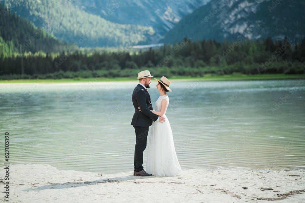 Beautiful married couple in their wedding dress at Lago di Landro, Italy Beautiful married couple in their wedding dress at Lago di Landro, Italy