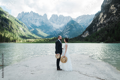 Beautiful married couple in their wedding dress at Lago di Landro, Italy