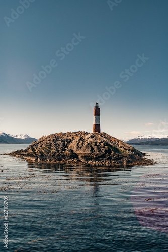 the lighthouse of Les Éclaireurs in ushuaia, tierra del fuego, end of the world, surrounded by a blue ocean in the beagle channel and a beautiful sky