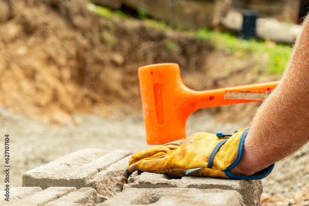 Landscaping Company Tending to A Front Lawn, Flower Bed Cutting Grass, Blowing Debris, and A Retaining Wall