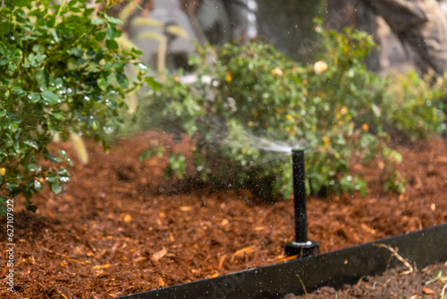 Landscaping Company Tending to A Front Lawn and Flower Bed Cutting Grass and Blowing Debris
