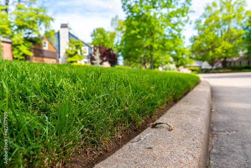 Obraz na płótnie Landscaping Company Tending to A Front Lawn and Flower Bed Cutting Grass and Blowing Debris w salonie