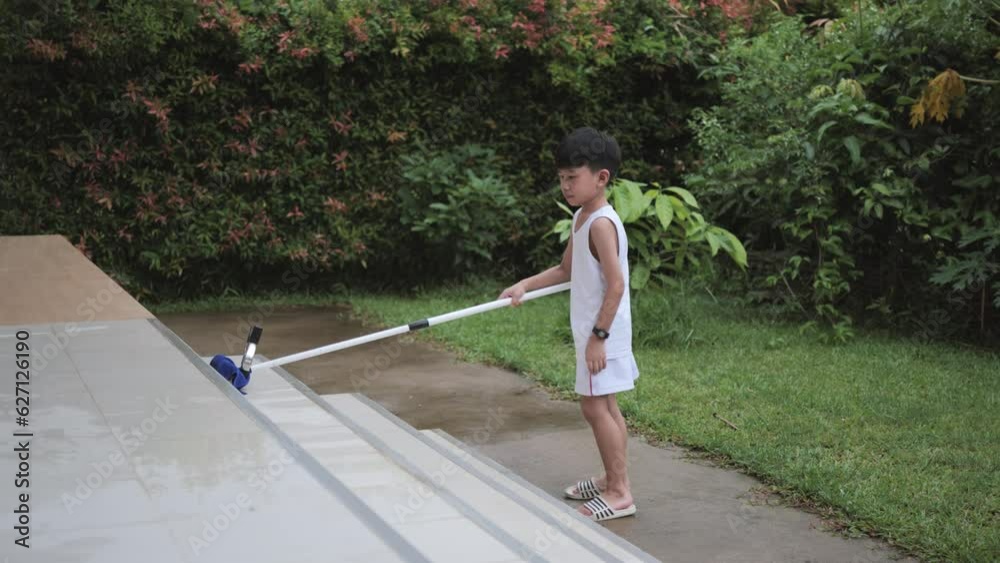 Asian boy is doing house chores by cleaning and wiping the floor of the balcony tiles with a water wiper mop. Asian boy is doing house chores by cleaning and wiping the floor of the balcony tiles with a water wiper mop.