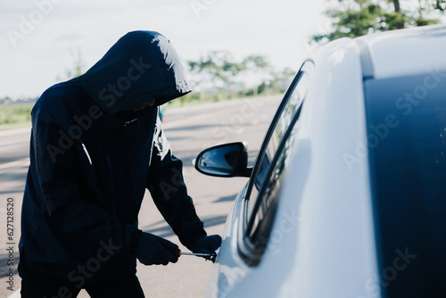 Close-up car thief hand holding screwdriver tamper yank and glove black. Man robber checking breaking entering alarm in a car stealing. Image about reflect society. photo
