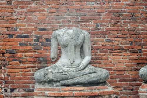 Ancient broken Buddha statues and old brick walls