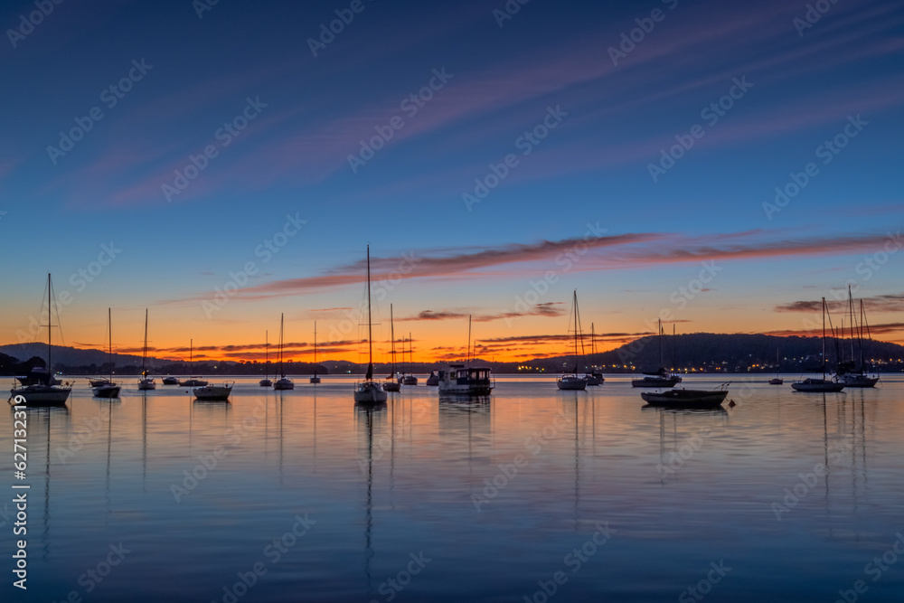 Beautiful sunrise with high cloud and boats on the water