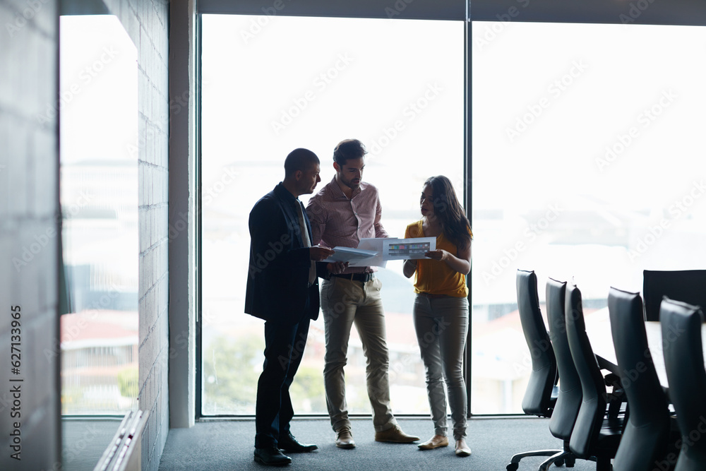 Sorting themselves out before the meeting. Full length shot of three businesspeople talking in the boardroom. Sorting themselves out before the meeting. Full length shot of three businesspeople talking in the boardroom.