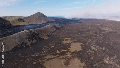 New land forming in Iceland from distant volcano eruption, black basalt rock photo