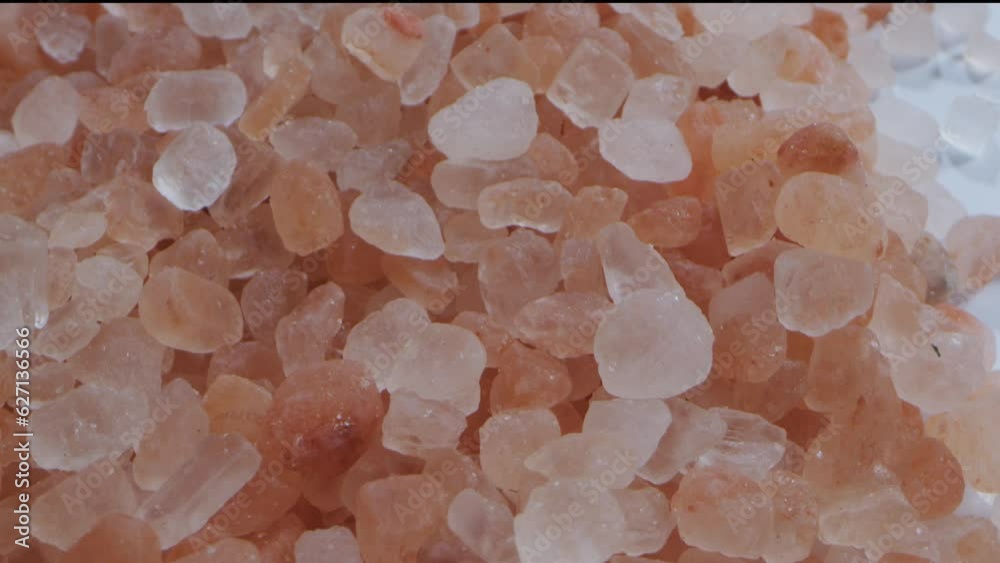 A moving shot of a pile of pink Himalayan salt. Close up view. Pink salt has anti-inflammatory properties that heal and soothe skin A moving shot of a pile of pink Himalayan salt. Close up view. Pink salt has anti-inflammatory properties that heal and soothe skin