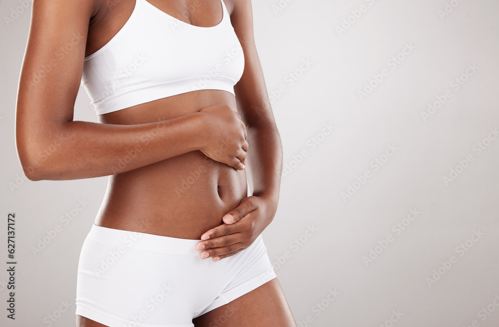 Hands, body and stomach of a woman for health and wellness on white background in studio. Fitness, gut and diet of person in underwear for weight loss, care or digestion and fertility with space