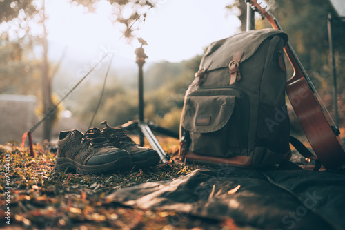 Camping equipment, bags, shoes, ukulele, tripod beside the tent in the morning. Object camp, Travel and vocation concept.