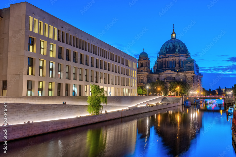 The modern backside of the City Palace, the cathedral and the river Spree in Berlin at night
