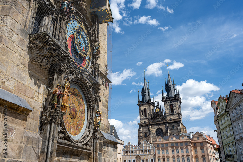 Obraz premium The famous astronomical clock and the Tyn church in Prague on a sunny day
