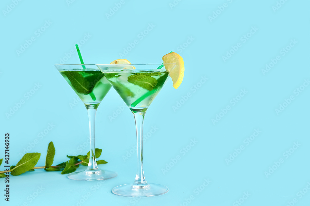 Glasses of tasty mojito on color background
