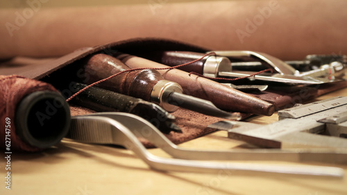 Pieces of leather and hand-tools on wooden table