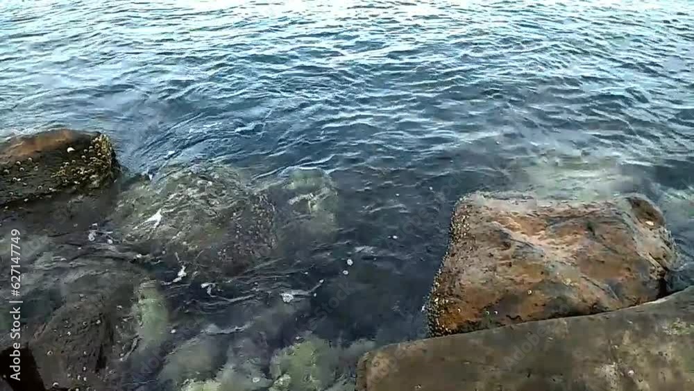 Blue sea water ripples between large rocks on the beach of Ulhee leue, Banda Aceh city Blue sea water ripples between large rocks on the beach of Ulhee leue, Banda Aceh city
