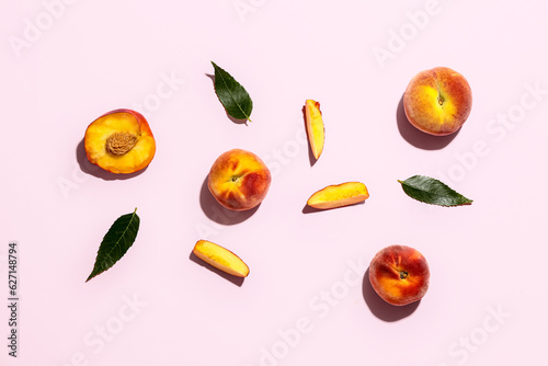Fototapeta Naklejka Na Ścianę i Meble -  Sweet peaches and leaves on pink background