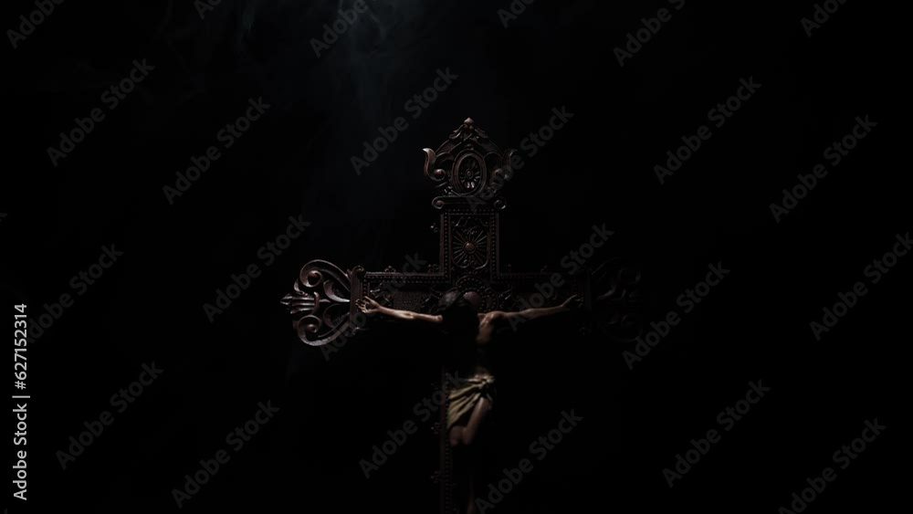 Jesus Christ on a wooden cross with a black background and smoke. Jesus Christ on a wooden cross with a black background and smoke.