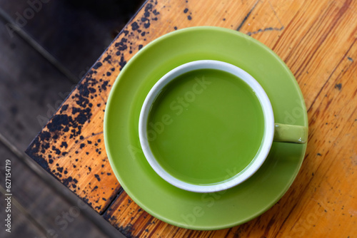 a cup of hot milk green tea on the table, top view. adding milk to green tea can result in a smoother and creamier texture with a milder flavor profile compared to plain green tea