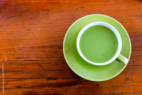 a cup of hot milk green tea on the table, top view. adding milk to green tea can result in a smoother and creamier texture with a milder flavor profile compared to plain green tea