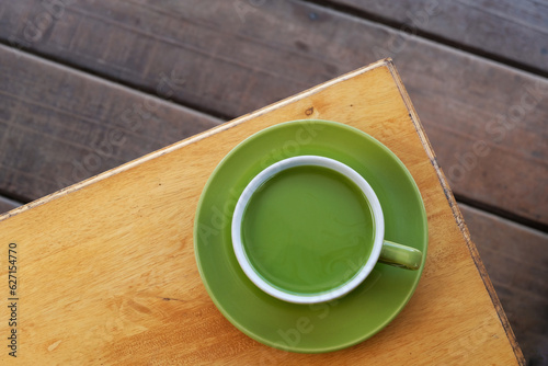 a cup of hot milk green tea on the table, top view. adding milk to green tea can result in a smoother and creamier texture with a milder flavor profile compared to plain green tea