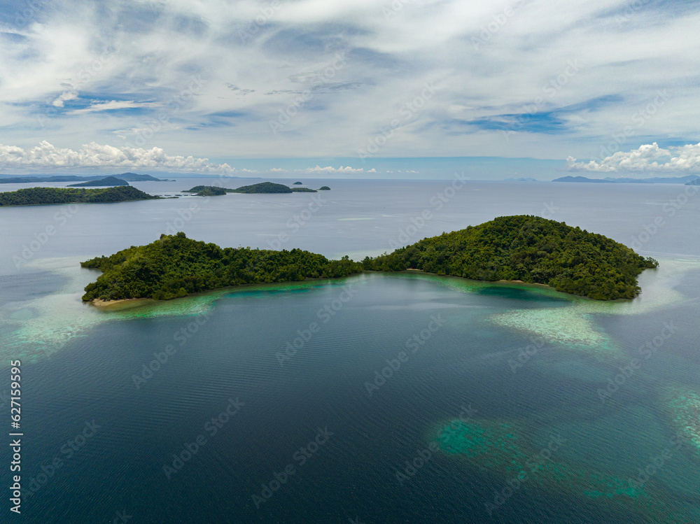 Aerial drone of islands with turquoise water and coral reef. Seascape in the tropics. Borneo, Sabah, Malaysia.
