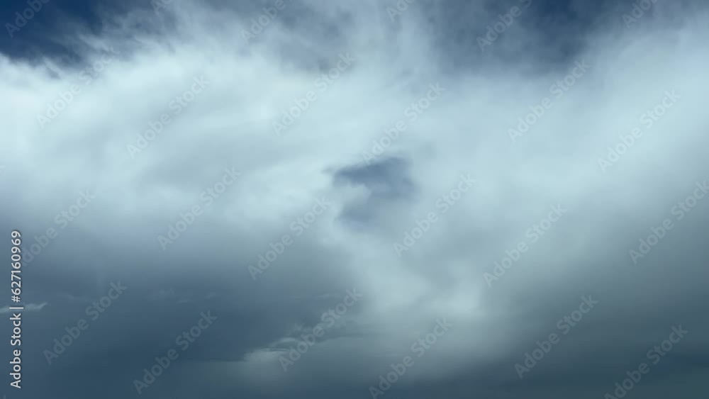 A pilot’s perspective shot from a jet cabin while flying through some fluffy clouds with a deep blue sky at the back. 10000m high. A pilot’s perspective shot from a jet cabin while flying through some fluffy clouds with a deep blue sky at the back. 10000m high.