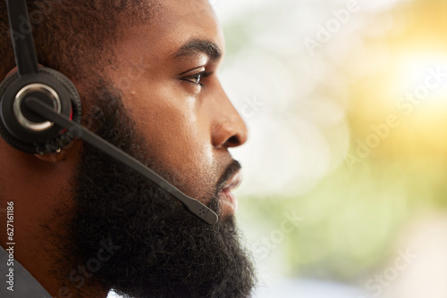 Face, profile of black man and call center, headset with mic and customer service employee, CRM and mockup space. Male consultant at help desk job, flare and serious for contact us and tech support