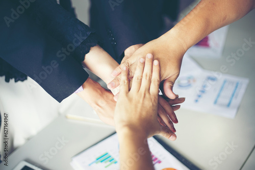 Happy Business people showing team work and giving five after signing agreement or contract with foreign partners in office interior.