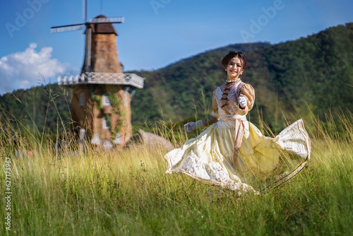Teenage girl in old fashion style costumes running with happy in the yellow field. vintage blouse costume. Historical dresses, victorian or edwardian era style dress