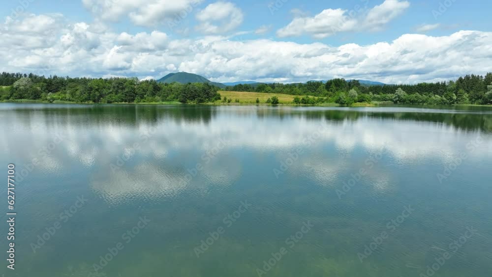 Aerial Drone Fly Close to Pristine Žovnek Lake Landscape Slovenia, Green Fields, Cloudy Summer Landscape, Clouds above Water, Braslovče Aerial Drone Fly Close to Pristine Žovnek Lake Landscape Slovenia, Green Fields, Cloudy Summer Landscape, Clouds above Water, Braslovče
