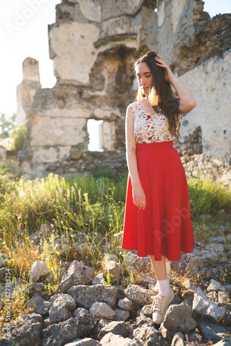 Fotografía a beautiful girl in a red skirt among the ruins of the old town