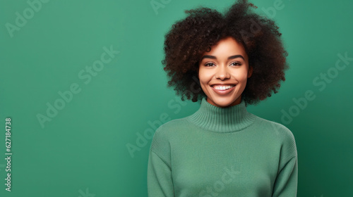 Portrait of a smiling young african woman wearing sweater standing isolated over green background