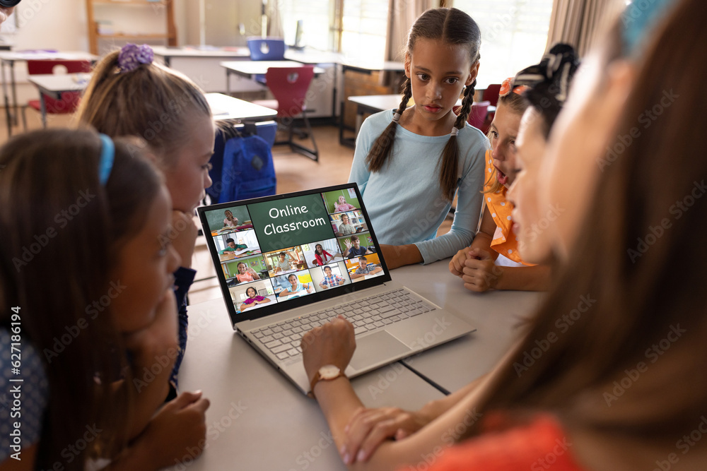 Fototapeta premium Asian female teacher and diverse students having a video conference on laptop at school