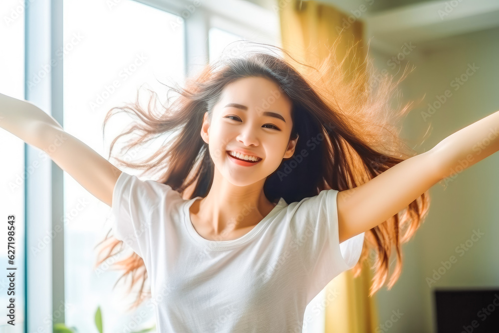 Positive chinese asian teen girl dancing at home. Happiness and well being concept.