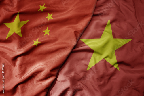 big waving national colorful flag of china and national flag of vietnam . photo