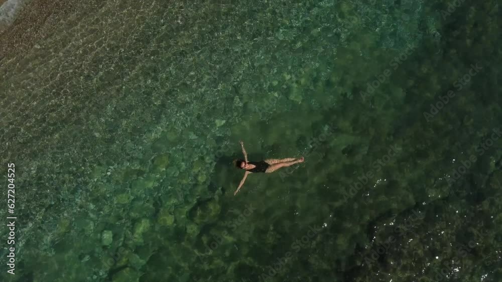 Pretty woman is swimming at the sea with clear water. Pretty woman is swimming at the sea with clear water.