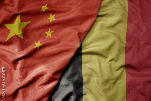 big waving national colorful flag of china and national flag of belgium .