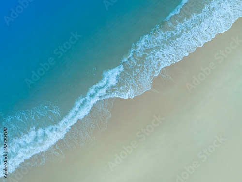 Beach Wave water in the Tropical summer beach with  sandy beach background © SASITHORN