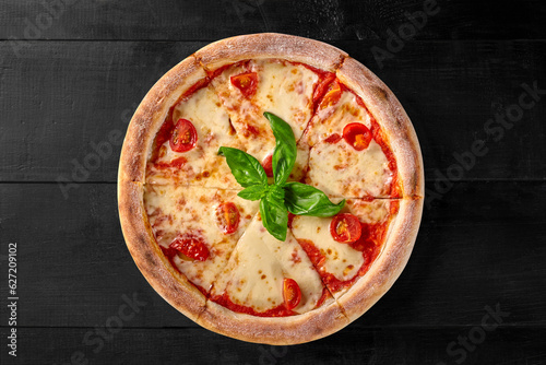 Pizza Margherita with pelati sauce, mozzarella, tomatoes and basil photo